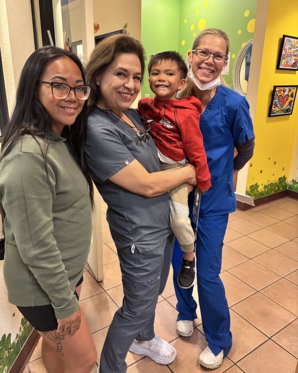 Happy child at Dentistry for Children clinic in Las Vegas with dental team
